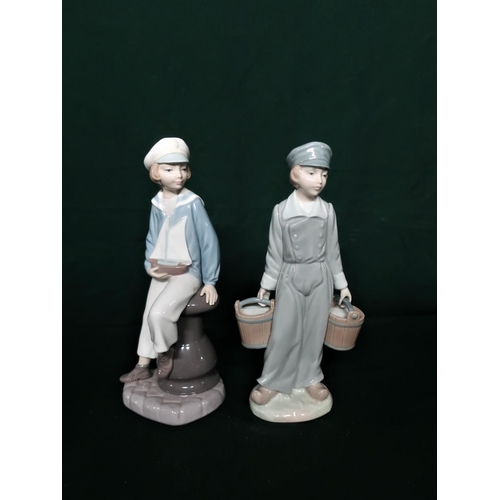 115 - Lladro figurine 4810 Boy With Yacht, H22cm and Lladro figurine 4811 Boy With Pails, H22cm.