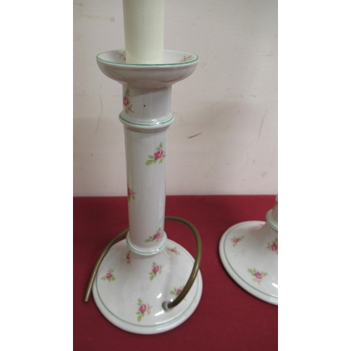 23 - Pair of Edwardian ceramic dressing table candlesticks decorated with roses, converted to electricity... 