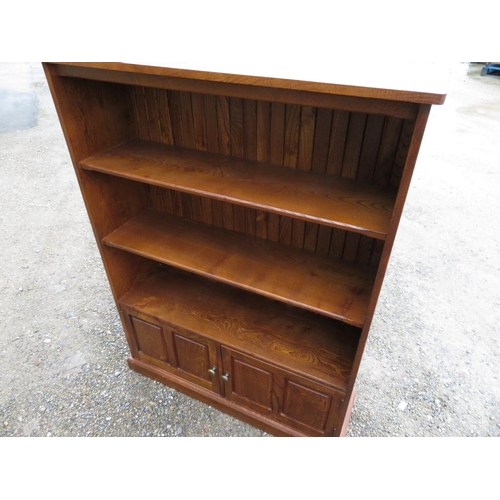 394 - Cryer Craft elm bookcase with boarded back and two shelves above two two-paneled doors on plinth bas... 