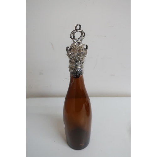 450 - Brown glass wine bottle, the plated mount and stopper cast with fruiting vines (37cm high)