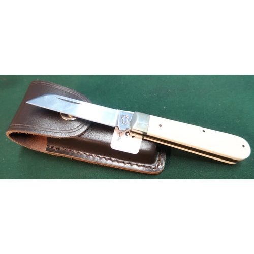 99 - Sheffield made single bladed pocket knife with ivory grips and working back detail, with leather bel... 