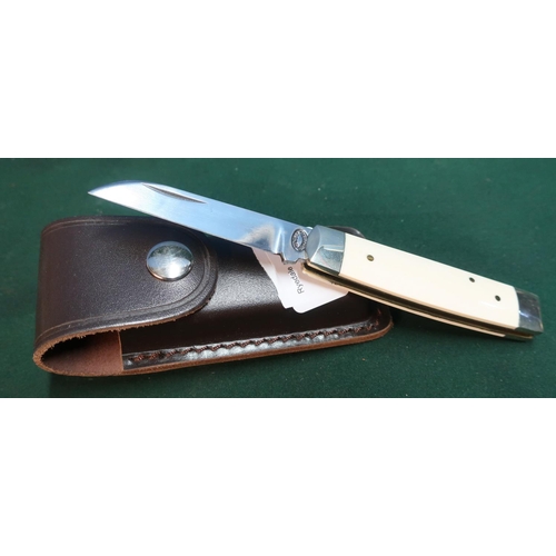 104 - Sheffield made single bladed pocket knife with ivory grips and working back detail, with leather bel... 