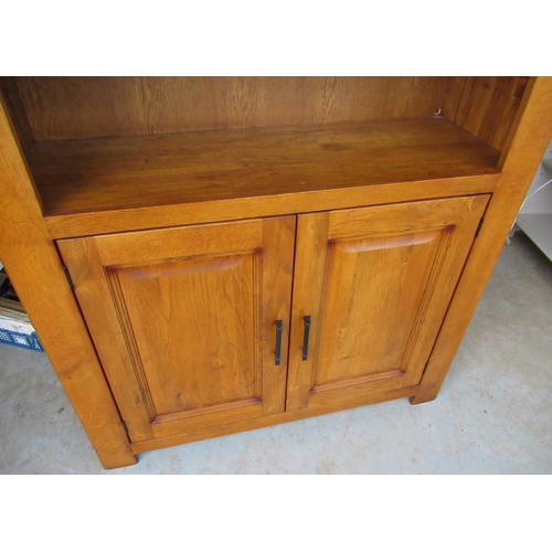 271 - Oak finish bookcase with two shelves above a pair of fielded panelled doors W110cm H190cm D40cm