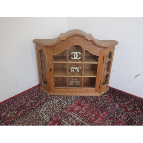 560 - Light oak arched top display cabinet decorated with Chanel No5 Paris London and New York decals H65c... 
