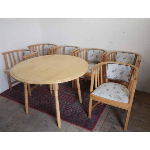 564 - Beech finish oval kitchen table with two drop leaves on turned legs a set of six rail back chairs on... 