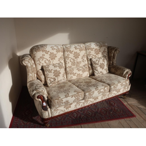 567 - Victorian style upholstered sofa with out scroll arms and wing back in brass sockets and casters wit... 