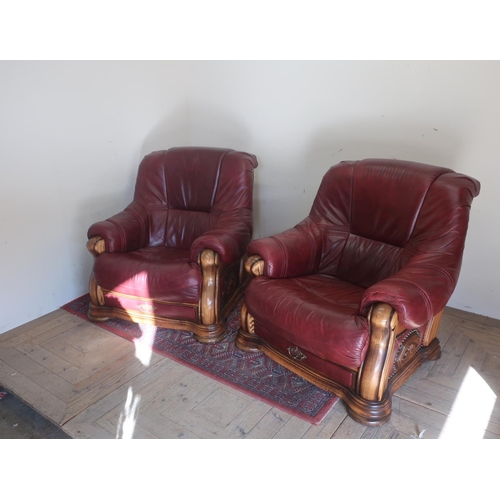 562 - Pair of red leather arm chairs, oak frames with fraise drawer