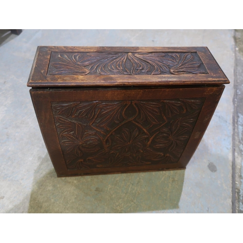 241 - An arts and crafts carved oak desktop stationary box, with hinged top and full front, revealing fitt... 