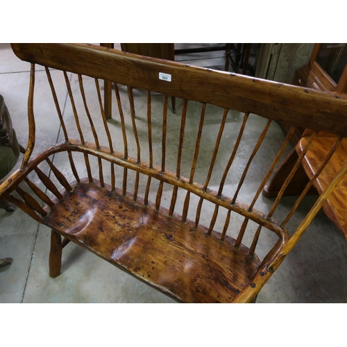 223 - Country made rustic two seat bench, with solid top rail, stick back and shaped seat, on out-splayed ... 