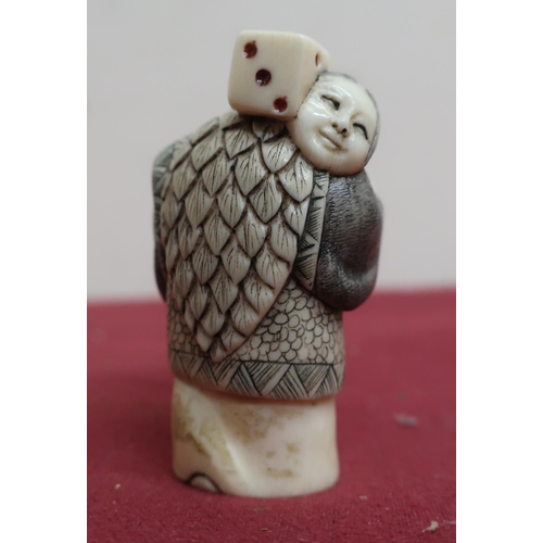 8 - Small late 19th C carved ivory Okimono of a figure carrying a dice, with scratched decoration, signe... 