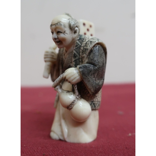 8 - Small late 19th C carved ivory Okimono of a figure carrying a dice, with scratched decoration, signe... 