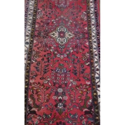 103 - 20th Century traditional pattern runner, red ground with central floral pattern ground and geometric... 