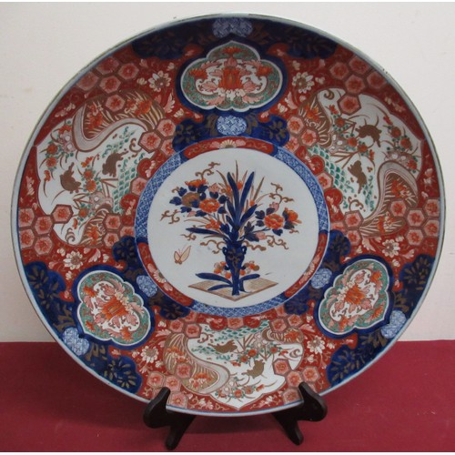81 - Large Japanese Imari polychrome circular charger, centre decorated with a profuse flower vase within... 