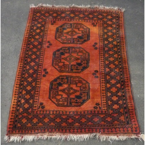 121 - 20th C Caucasian rug, burnt orange ground, three central octagonal medallions, in geometric border, ... 