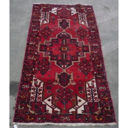 122 - 20th C Caucasian Iranian pattern rug, red ground central geometric medallion surrounded by exotic bi... 