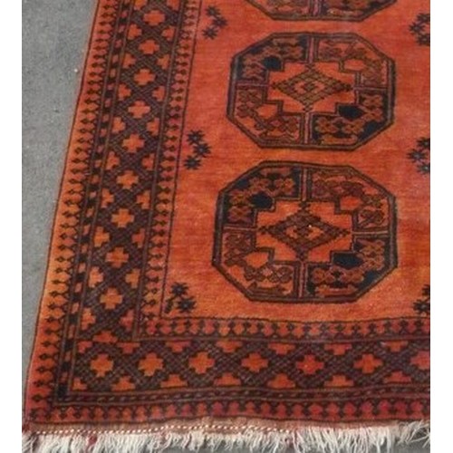 121 - 20th C Caucasian rug, burnt orange ground, three central octagonal medallions, in geometric border, ... 