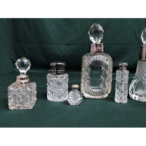 129 - Collection of early 20th C and later cut glass scent bottles, with silver hallmarked collars and top... 