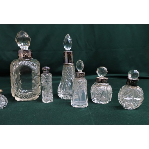 129 - Collection of early 20th C and later cut glass scent bottles, with silver hallmarked collars and top... 