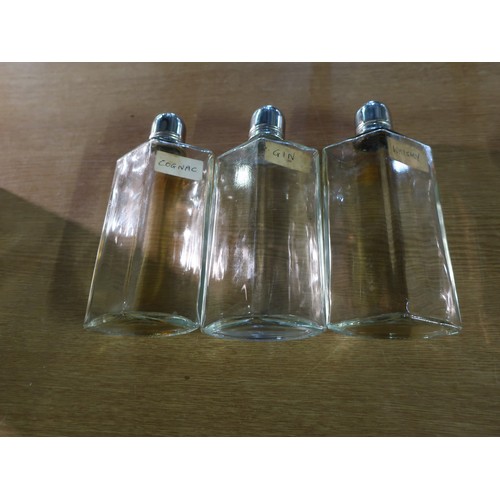 255 - A faux crocodile skinned case containing three fitted spirit bottles with tot lids, labelled 