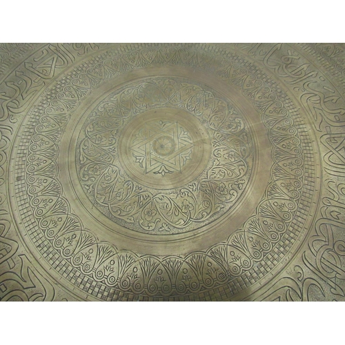 281 - Indian brass table top engraved with stylised motif, on a black Moorish style folding stand D58cm H5... 