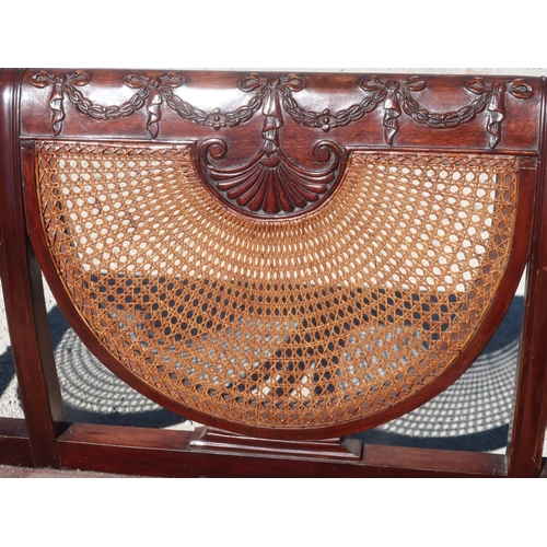 1319 - Geo.III style Bergere sofa, with ribbon tied back rail above three cane panels, double cane arms on ... 