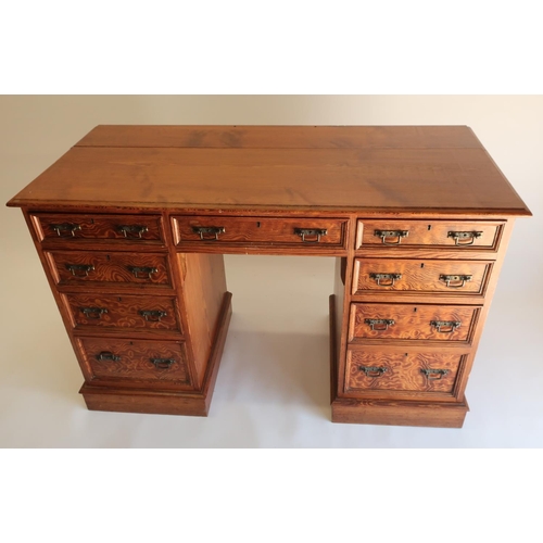1297 - Victorian pitch pine kneehole desk, moulded top above nine drawers with angular brass handles, on a ... 