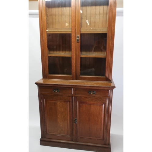 1298 - Edwardian oak bookcase with moulded cornice and two glazed doors enclosing four adjustable shelves, ... 