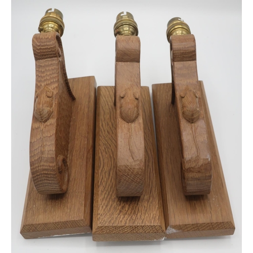 1006 - Robert Mouseman Thompson - a set of three adzed oak wall lights with scroll carved detail and signat... 