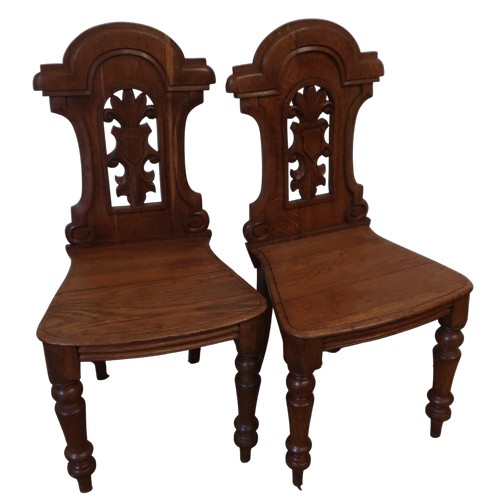 1308 - Pair of Victorian golden oak hall chairs, with arched Fleur de Lys backs and solid seats on turned s... 