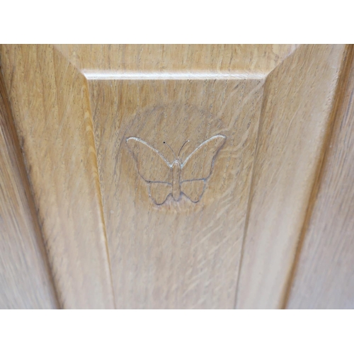 1060 - Andrew Conning Butterfly Furniture - an oak low dresser, with two fielded panelled doors on faceted ... 