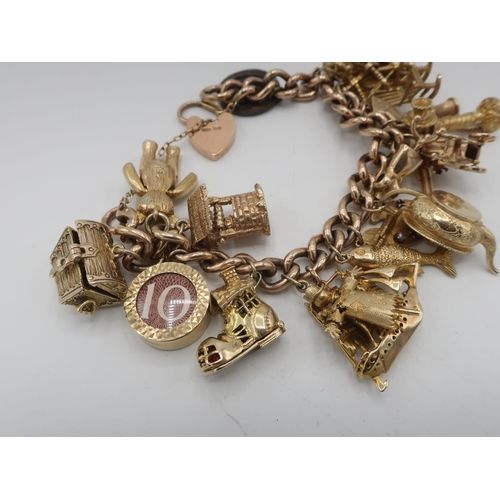 1143 - 9ct gold hallmarked charm bracelet hung with eighteen various charms including treasure chest, artic... 