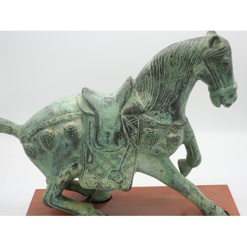 1248 - Large green verdigris patinated cast metal model of a Tang style horse in typical pose, on wooden pl... 