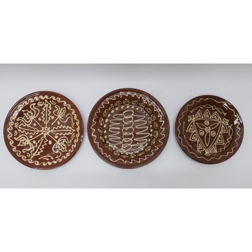 1242 - Three early 20th Century slip ware chargers, white slip decorated with geometric designs D36cm max (... 