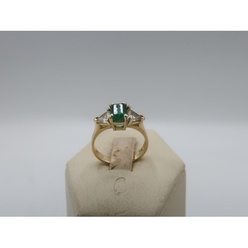 1135 - 14K gold ring, central emerald of approx .70ct, with two triangular diamonds .56ct, stamped 14k, wit... 