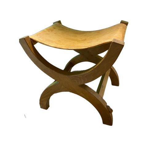 1003 - Robert Mouseman Thompson - an oak stool with stitched slung leather seat on X framed curved supports... 