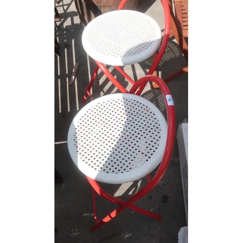 18 - Two red metal framed folding stools with white plastic seats