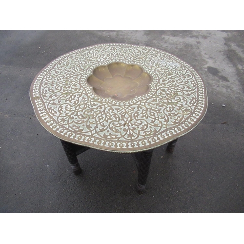 245 - 20th C Indo Persian Benares table, beaten brass top with dished centre extensively carved folding ha... 