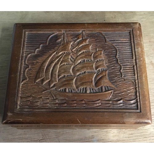 478 - Wooden box with a carved design to the lid depicting a ship at sea, containing a quantity of pre-dec... 