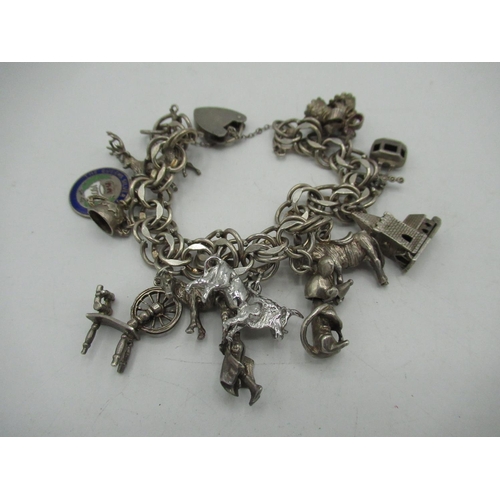 25 - Sterling silver charm bracelet with various charms including animals, Queens Silver Jubilee, spinnin... 