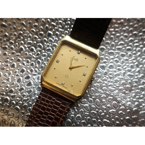 47 - Grath Quartz wrist watch. 14ct gold case on brown leather strap. Brushed gold case with snap on back... 