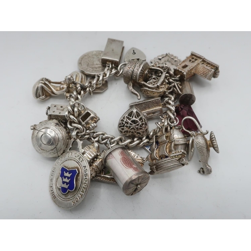 121 - Sterling silver charm bracelet with ten shilling currency, Hull crest, ship, St Christopher, 1940 Qu... 