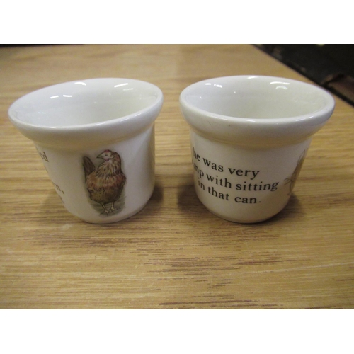 148 - Two Wedgwood Peter Rabbit egg cups, W.H. Goss 'Buxton' souvenir egg cup, two Carlton ware egg cup, e... 