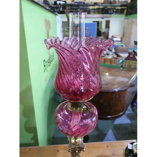 684 - Early 20th C oil lamp on brass corinthian capped column and stepped base, cranberry glass reservoir ... 