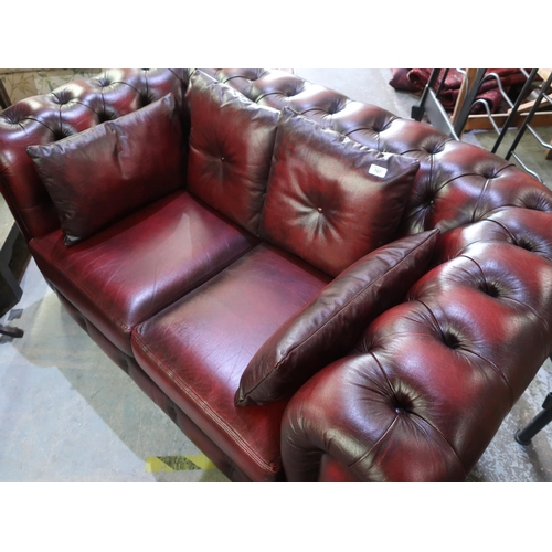707 - Small red ox blood leather Chesterfield sofa, with deep buttoned back and arms, two seat cushions an... 