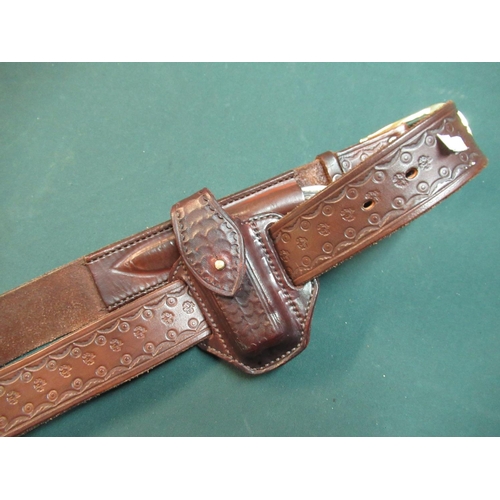 112 - Quality tooled leather belt with brass buckle marked Harry Boden, with side pouch with an early sing... 