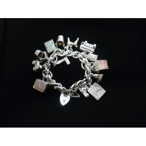 37 - Silver charm bracelet with heart padlock clasp , charms include £1 and £10 notes, London bus, Big Be... 