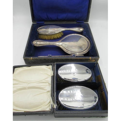 79 - Hallmarked sterling silver dressing table set of two brushes and mirror, cased Birmingham, 1921 anot... 