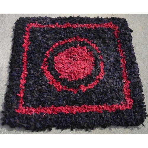 696 - Mid C20th 'Clippy' type rug, blue and black ground with central red roundel and borders, 90cm x 90cm