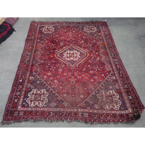 698 - C20th Turkish wool rug with central geometric medallion on red ground surrounded by stylised floral ... 