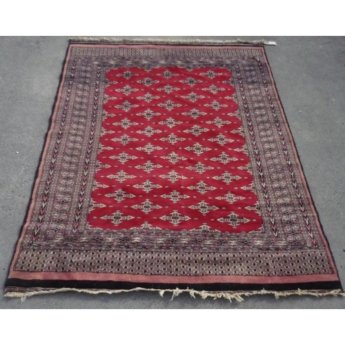 699 - C20th Caucasian pattern wool rug with red ground with patterned centre set with geometric motifs sur... 